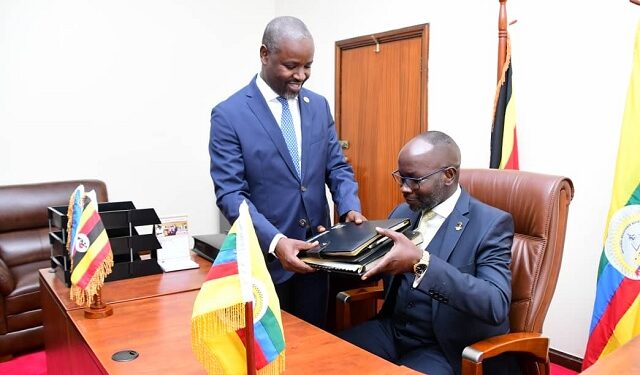 Tayebwa (standing) hands over to Hon. Hamison Obua